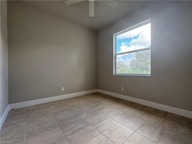 Tiled empty room with ceiling fan