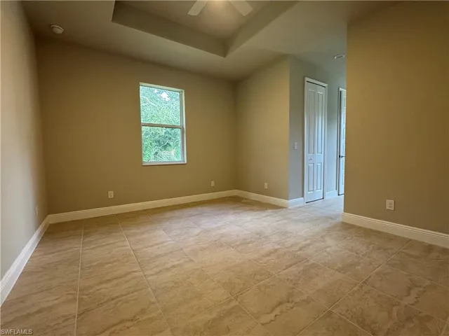 Empty room with a tray ceiling and ceiling fan