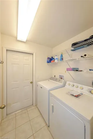Interior laundry room with washing machine and dryer is off the master bedroom hallway and adjacent to...