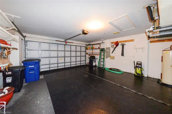 the 2-car attached garage featuring electric panel, garage door opener.