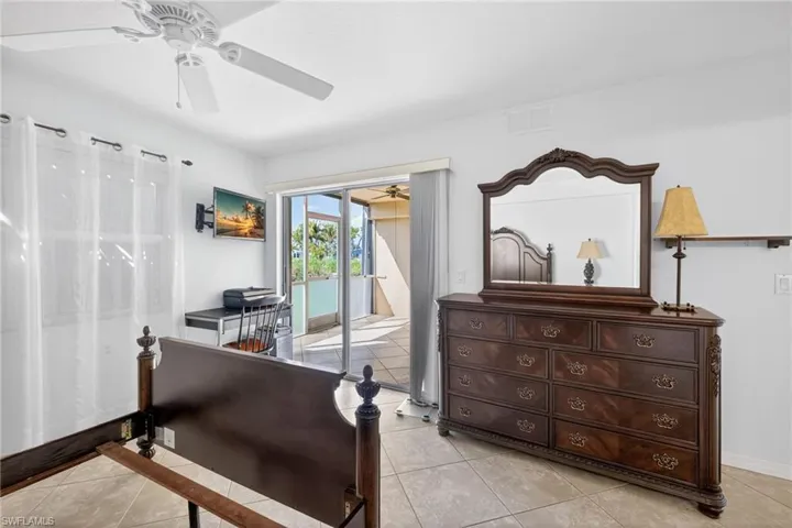 Bedroom featuring a ceiling fan, light tile patterned floors, and access to outside