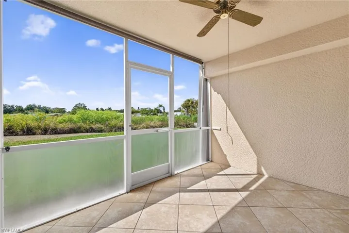 Unfurnished sunroom featuring ceiling fan