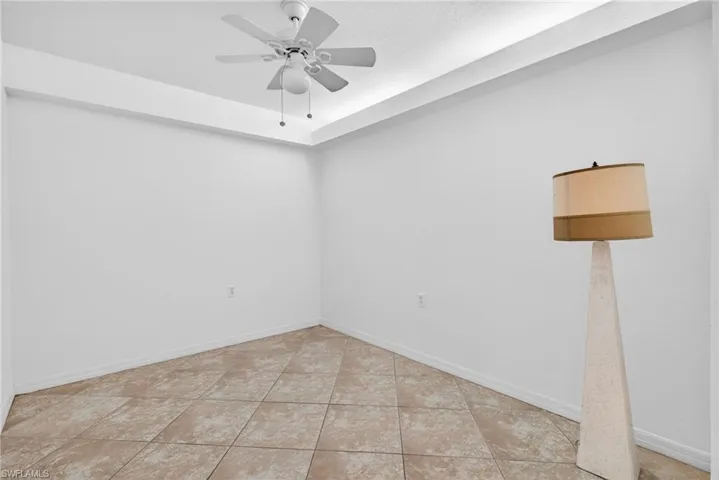 Spare room featuring ceiling fan and light tile patterned flooring