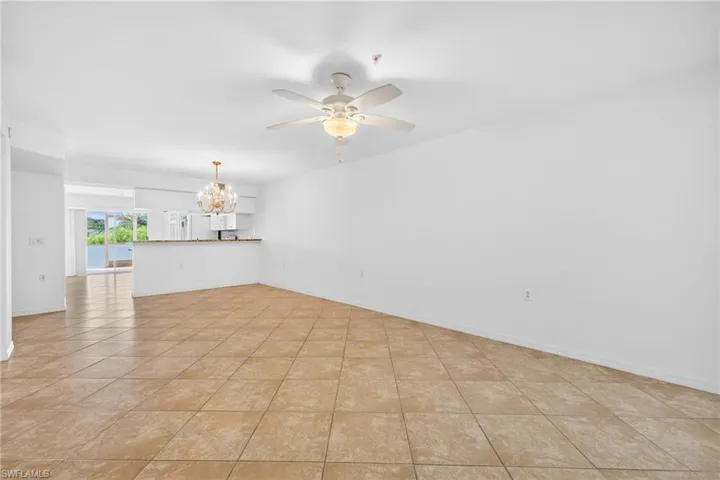 Empty room featuring suspended lighting, ceiling fan, and light tile patterned floors