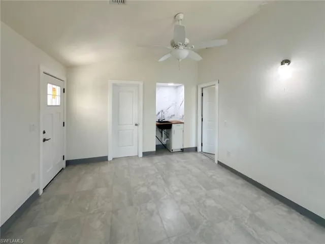 Unfurnished living room featuring lofted ceiling and ceiling fan