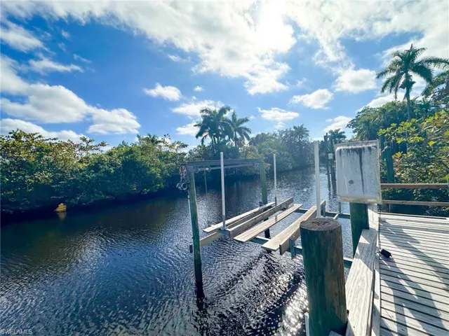 Dock area featuring boat lift and a water view
