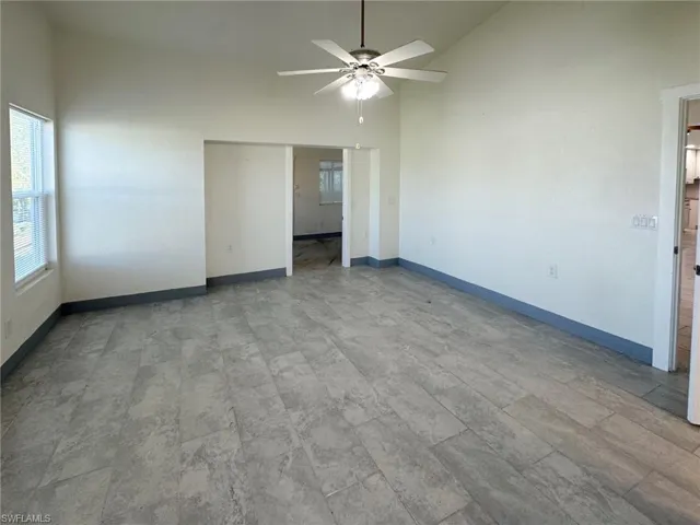 Unfurnished bedroom featuring high vaulted ceiling and ceiling fan