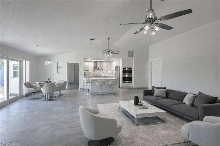 VIRTUALLY STAGED-Living room featuring a ceiling fan and vaulted ceiling