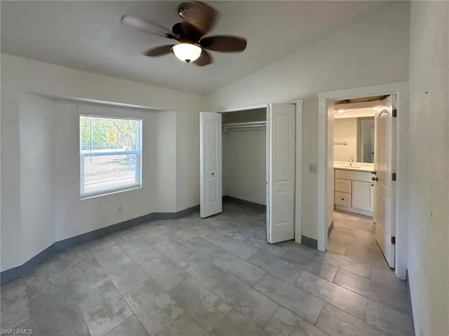 Unfurnished bedroom with vaulted ceiling, a ceiling fan, and a closet