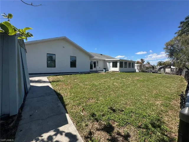 Back of house featuring a yard and stucco siding