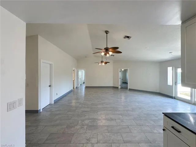 Unfurnished living room with lofted ceiling and a ceiling fan