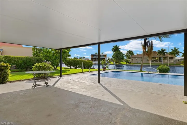 View of pool with a water view and a lawn
