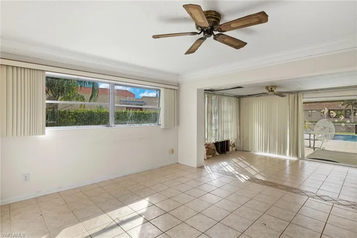 Tiled spare room with ornamental molding and ceiling fan