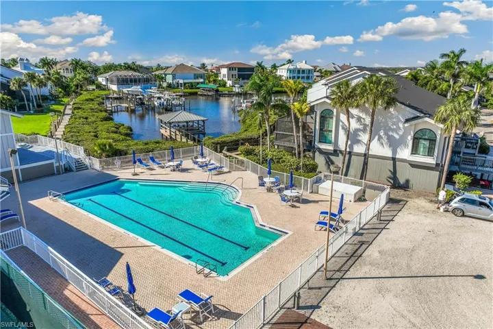 View of Community swimming pool with a water view and a patio area
