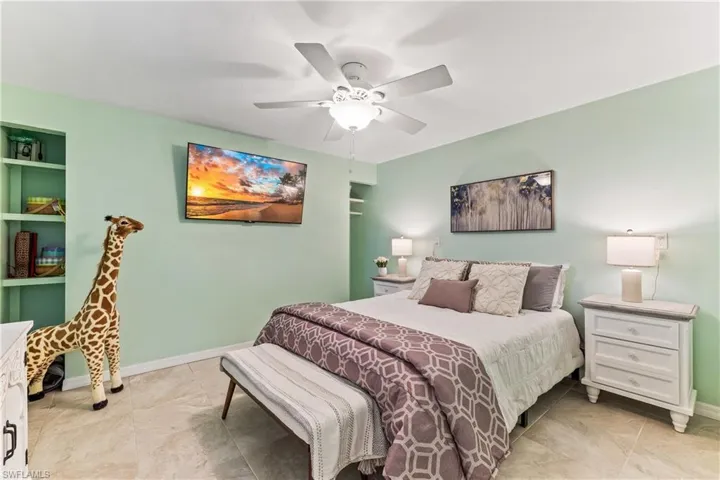 Tiled bedroom featuring ceiling fan