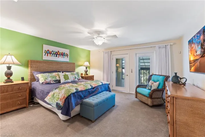 Bedroom with ceiling fan, access to exterior, and light colored carpet