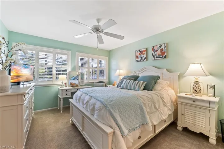 Bedroom with dark colored carpet and ceiling fan