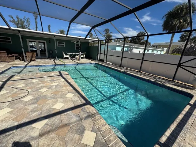 View of swimming pool with a patio area, french doors, and glass enclosure