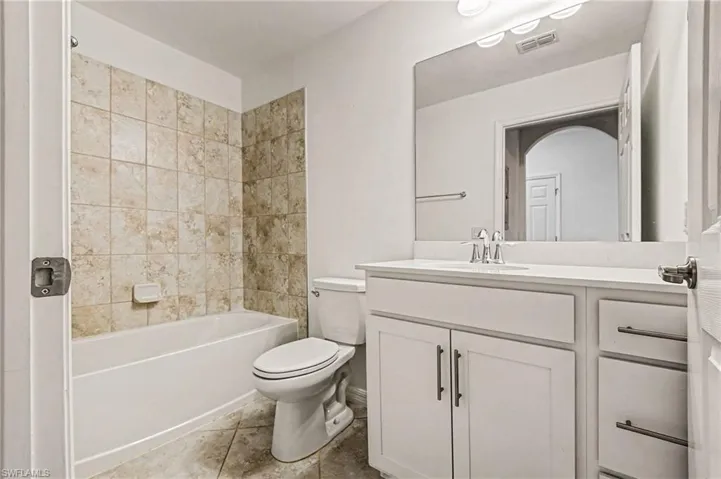 Full bathroom with vanity, shower / washtub combination, and light tile patterned flooring