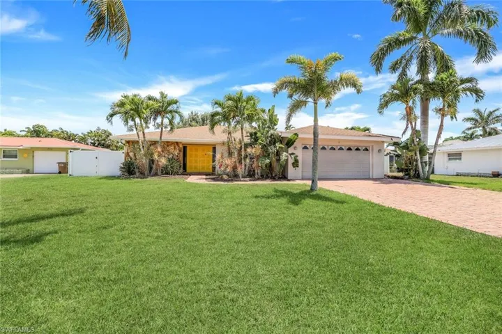 Single story home with a garage and a front lawn