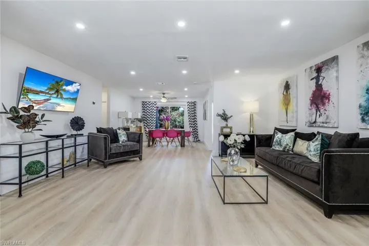 Living room with ceiling fan and light hardwood / wood-style flooring