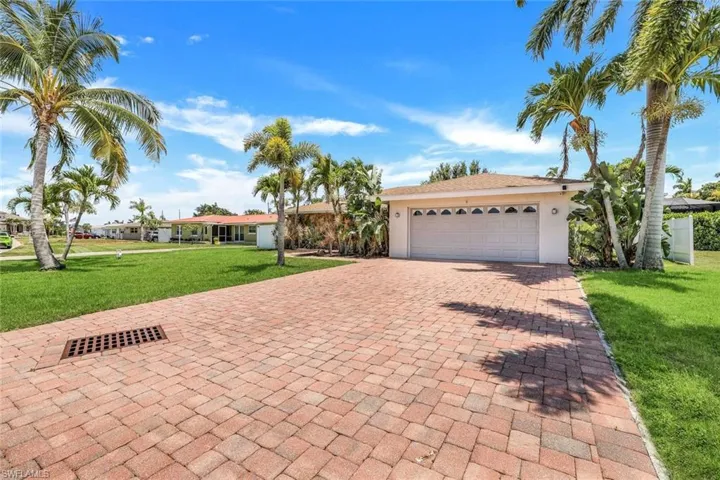 View of front of house with a garage and a front lawn