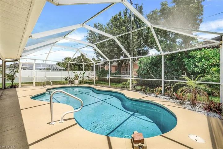 View of pool featuring glass enclosure and a patio area