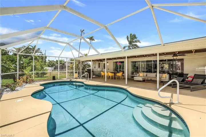 View of swimming pool with a patio, glass enclosure, an outdoor living space, and ceiling fan