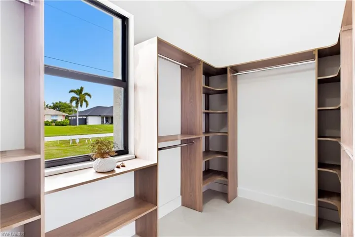 Custom closet system featuring wood-finish shelving, integrated hanging rods, and built-in drawers