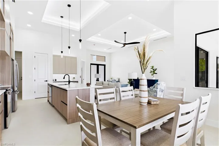 Kitchen featuring a central island with a sink, stainless steel appliances, pendant lighting, and recessed ceiling lighting
