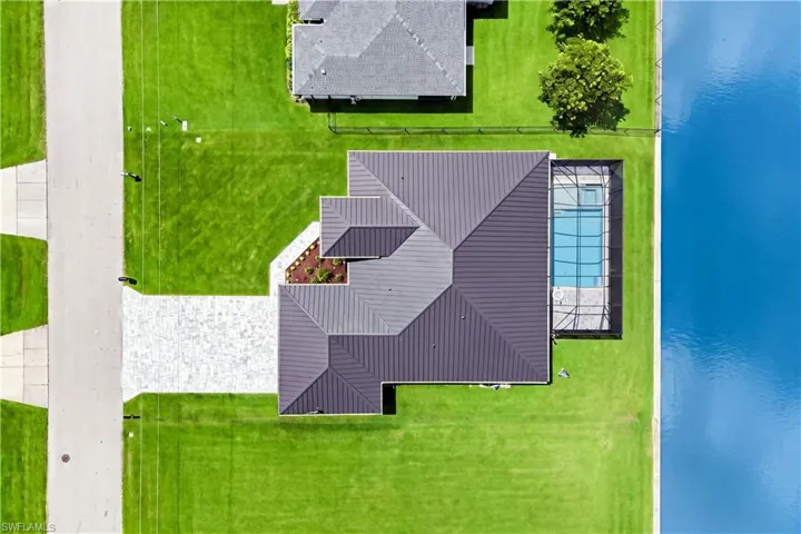 Metal roof, screened-in swimming pool, paved driveway, landscaped entry, and waterfront location