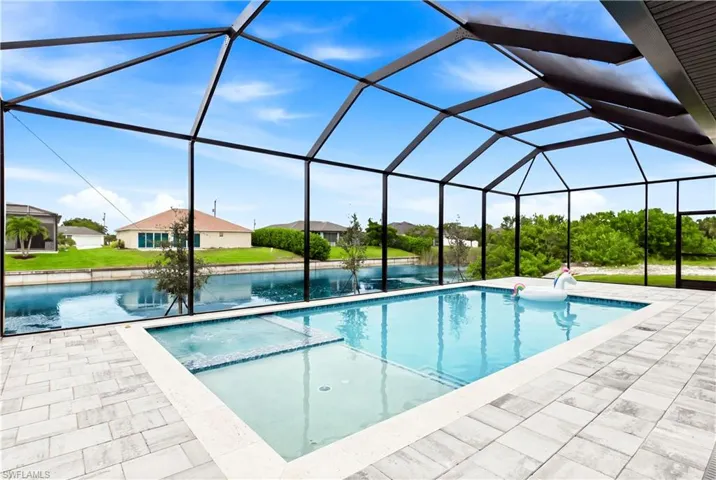 Screened-in outdoor living space featuring a rectangular pool and an integrated spa