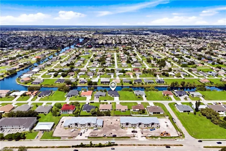 Canal-front property within a residential neighborhood featuring established infrastructure and proximity to a major roadway