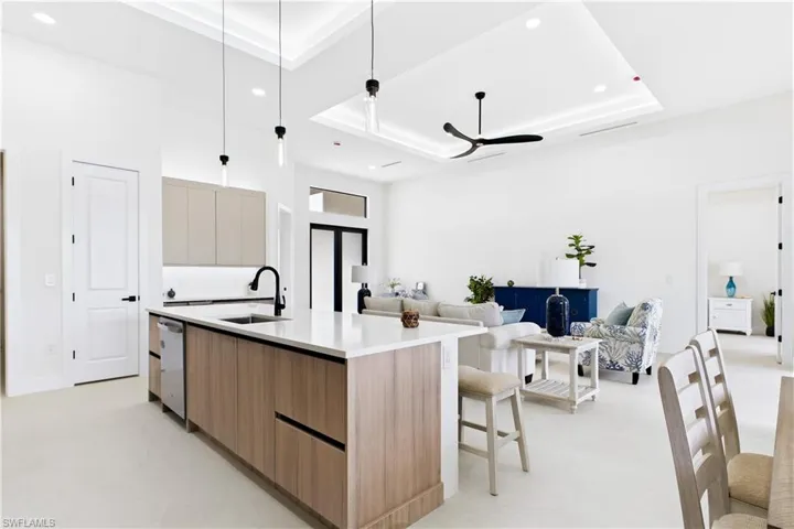 Kitchen island with wood-finish cabinetry, white countertop, and integrated stainless steel dishwasher