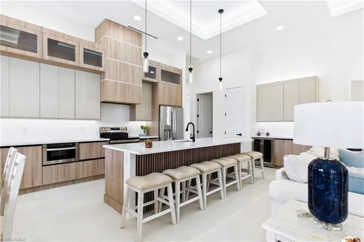 Gourmet kitchen featuring a large central island with seating, stainless steel appliances, and integrated cabinetry
