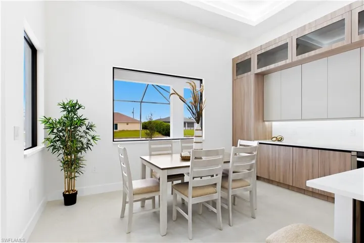 Recessed ceiling, built-in cabinetry, under-cabinet lighting, and large windows