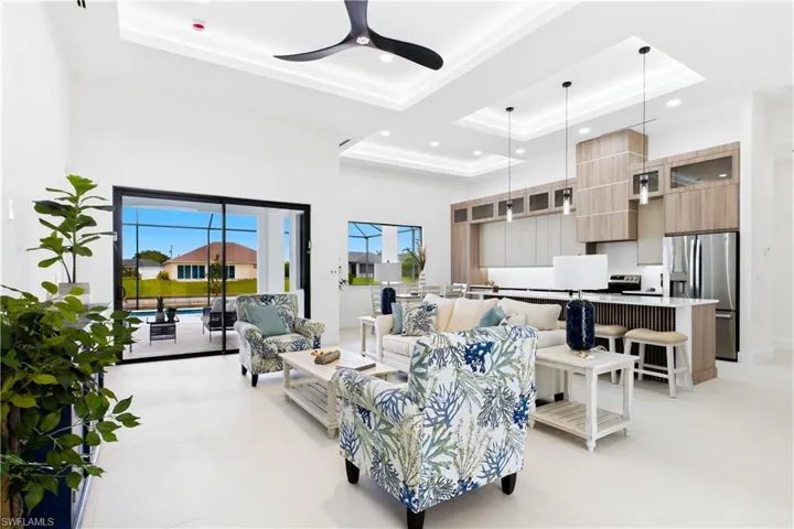 Tray ceilings with recessed lighting, large format tile flooring, and floor-to-ceiling sliding glass doors