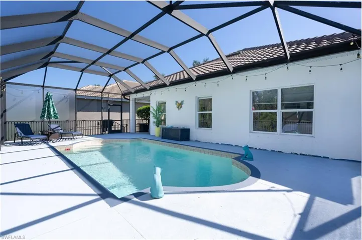 View of swimming pool with a sunroom, a lanai, and a patio area