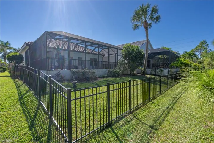 Back of house with a sunroom, a fenced backyard, and a lanai