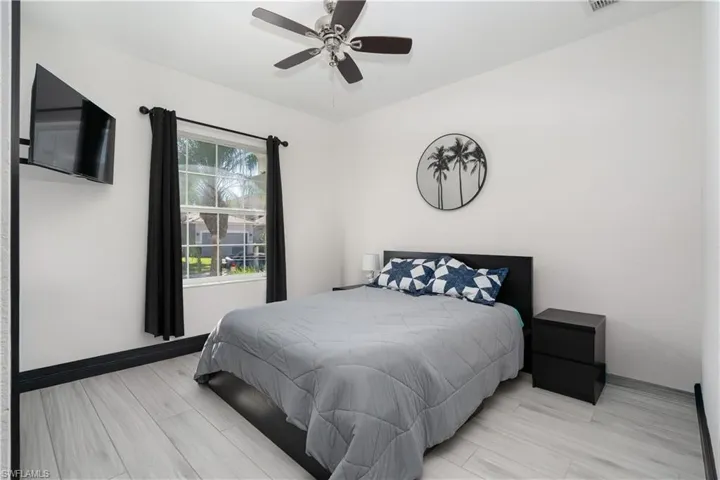 Bedroom with wood tiled floors and a ceiling fan