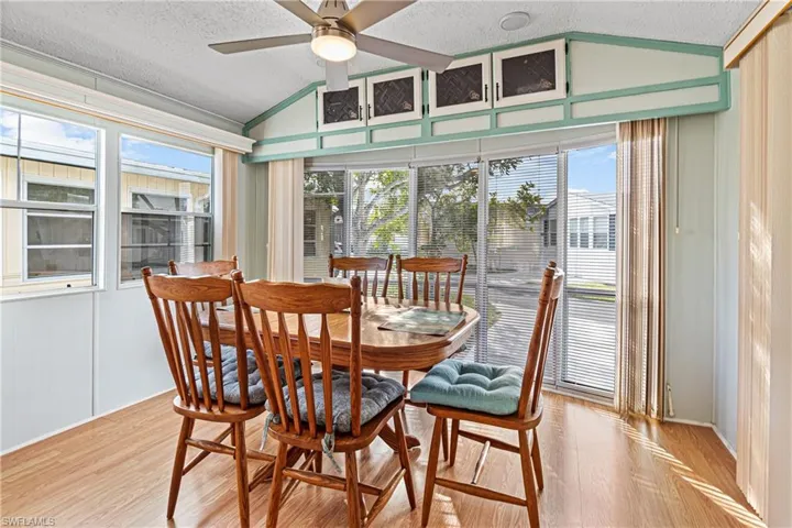Dining room with light wood-style flooring, a textured ceiling, and a ceiling fan
