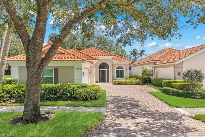 Entry with a paver driveway, stucco exterior, and terracotta tile roof