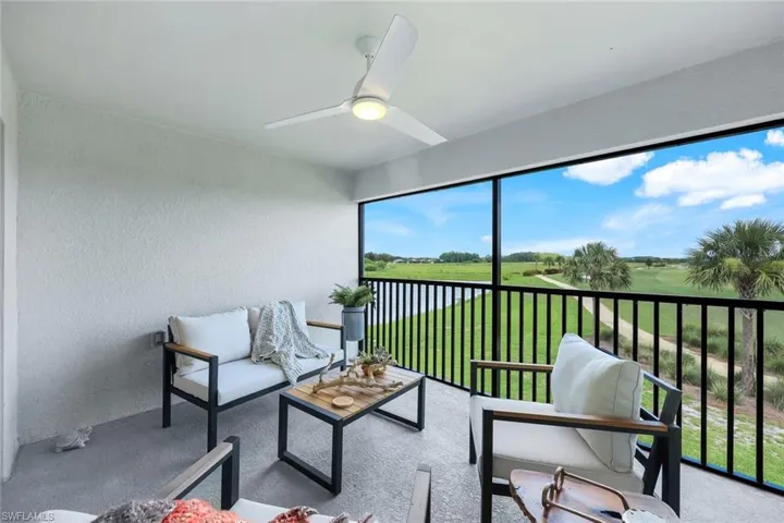 Sunroom / solarium featuring a textured wall, a water view, carpet flooring, and golf course view