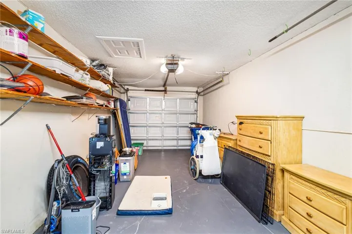 Garage space with a panel-style door, concrete flooring, and built-in shelving, AI Altered