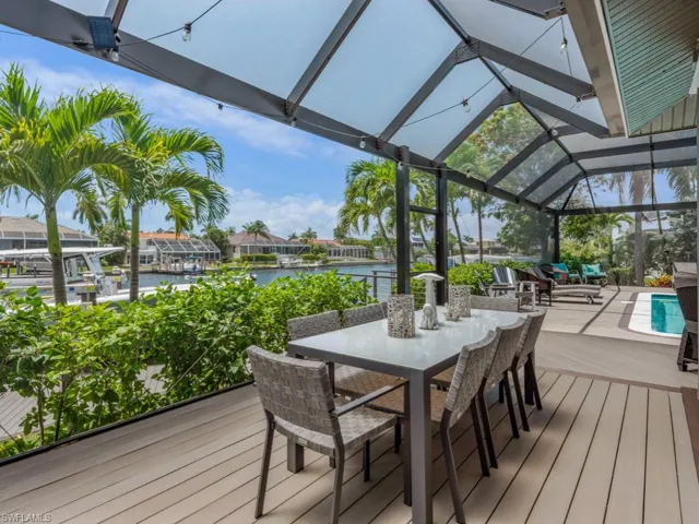 Deck with a water view, outdoor dining space, and a lanai