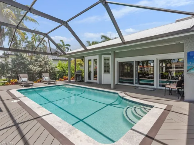 Swimming pool with french doors, grilling area, a patio, and glass enclosure