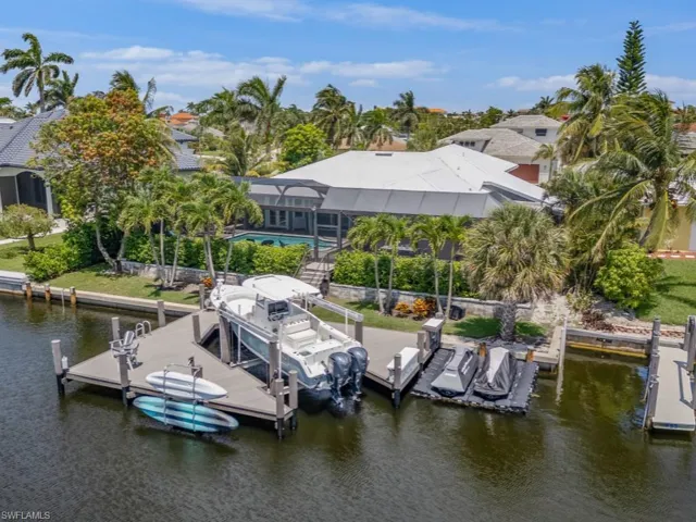 Dock area featuring a water view, boat lift, and a pool