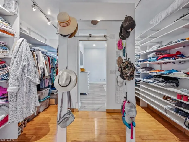 Spacious closet with wood finished floors and a barn door