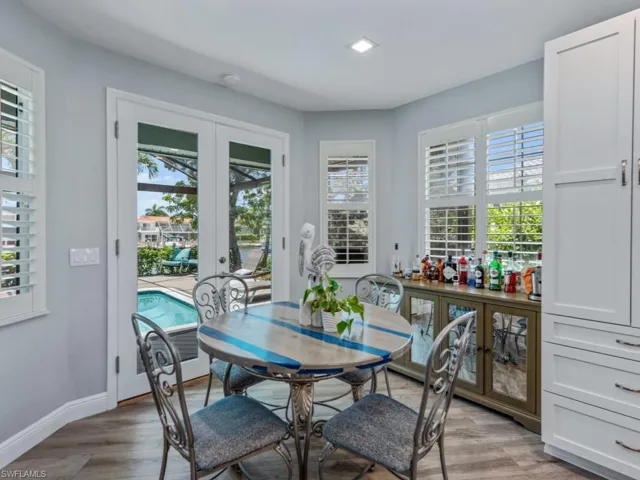 Dining space with french doors, healthy amount of natural light, and light wood finished floors