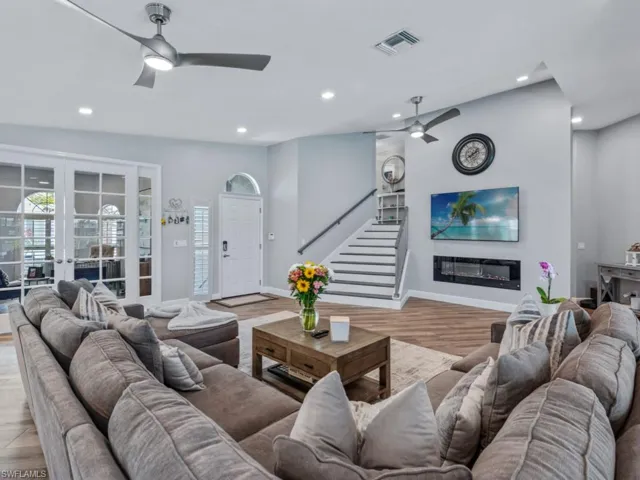 Living area with a ceiling fan, stairs, recessed lighting, french doors, and light wood-type flooring